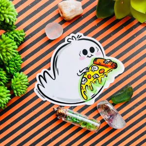 May include: A white ghost with a cute face holding a slice of pizza with skulls and dripping green cheese. The pizza is orange and yellow with a red crust.