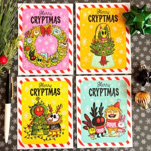 Może przedstawiać: Cztery kolorowe kartki świąteczne z napisem "Merry Cryptmas". Każda karta zawiera unikalne ilustracje z kreskówek z czerwono-białą obwódką w paski. Karty mają różowe, żółte i niebieskie tło z płatkami śniegu.