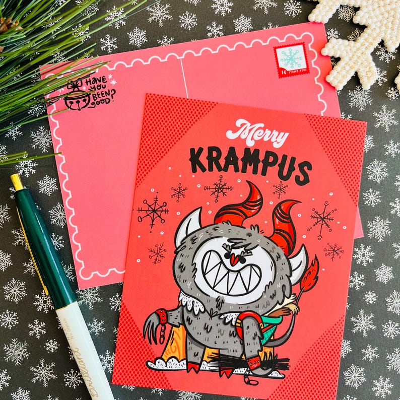 May include: A red and white postcard with a cartoon illustration of Krampus, a mythical Christmas creature. The text "Merry Krampus" is written in black letters on the postcard.