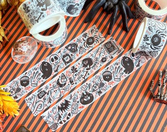 May include: Halloween-themed decorative tape rolls with black and white illustrations of ghosts, skulls, and spiders. The tape features the text "Creep Real" and other spooky graphics. The background is orange and black striped.