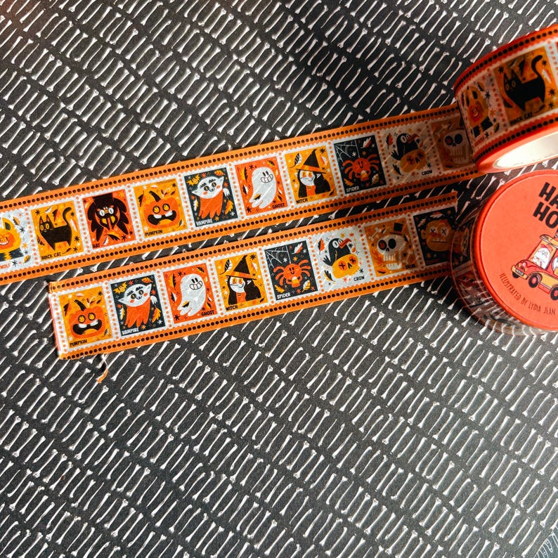 Puede incluir: Un rollo de cinta decorativa naranja y blanca con un patr&oacute;n repetitivo de personajes de Halloween que incluye un gato negro, calabaza, vampiro, fantasma, bruja, ara&ntilde;a y cuervo, con una etiqueta redonda naranja que dice Happy Halloween.