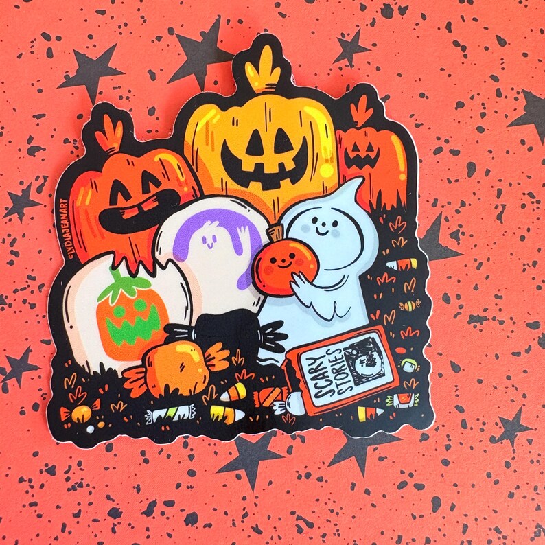 May include: A Halloween-themed sticker featuring cartoon pumpkins, ghosts, and candy. The sticker has a black border and is set against a red background with black star shapes. The text "Scary Stories" is visible on a book.