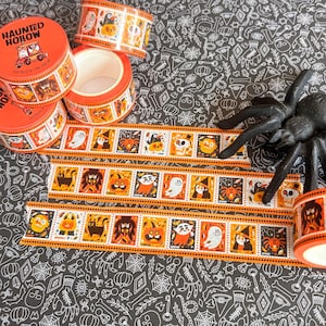 Puede incluir: Tres rollos de cinta decorativa washi naranja y blanca con un patr&oacute;n repetitivo de personajes de Halloween que incluye fantasmas, calabazas, murci&eacute;lagos y brujas. El texto Haunted Hollow est&aacute; impreso en el rollo superior con un coche de dibujos.