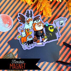 May include: A flexible magnet featuring a Halloween-themed illustration of several cartoon characters, including a ghost, a skeleton, and a grim reaper. The magnet is on a black surface with the words "Flexible Magnet" in a banner.
