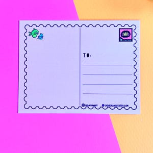 May include: A light purple postcard with a scalloped border and a stamp that says "HI". The postcard has lines for the recipient's address and the text "TO:". The postcard also has two small fish illustrations.