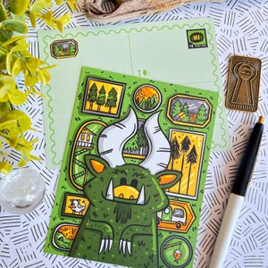 May include: A green monster with large horns and a toothy grin is surrounded by small framed illustrations of trees and a cabin. The postcard is green with a light green background and has a "HI" stamp in the top right corner.