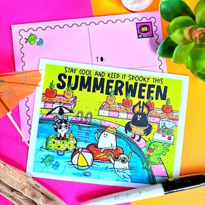 May include: A colorful postcard with the text "STAY COOL AND KEEP IT SPOOKY THIS SUMMERWEEN." The illustration depicts cartoon characters in a swimming pool. A pink postcard with a stamp is behind the main card.