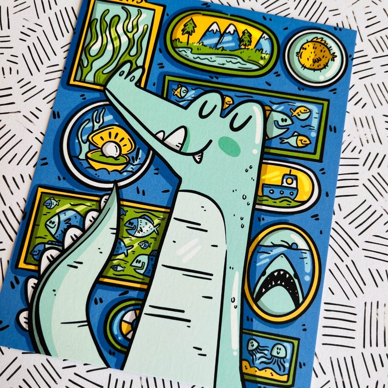 May include: A light blue alligator with a toothy grin is looking at a framed picture of a pearl in a seashell. The alligator is surrounded by other framed pictures of sea life, including fish, a shark, a pufferfish, and a boat.