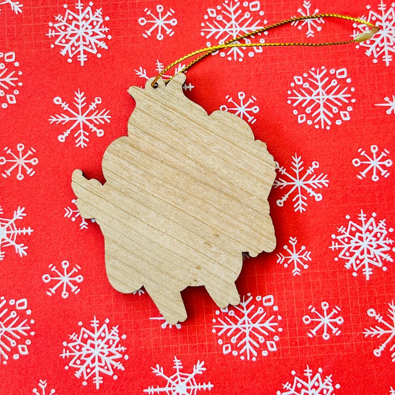 May include: A wooden Christmas ornament shaped like a cartoon character. The ornament is unpainted and ready to be decorated.