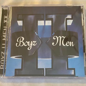 May include: A CD case featuring the album "Boyz II Men II". The cover art has a blue gradient background with the words "Boyz" and "Men" in white script. The album title is printed vertically on the spine.