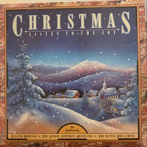 May include: A square vinyl record cover titled CHRISTMAS LISTEN TO THE JOY featuring a snowy landscape with pine trees, a small village, and mountains under a night sky. The Hallmark logo and artist names are printed at the bottom.