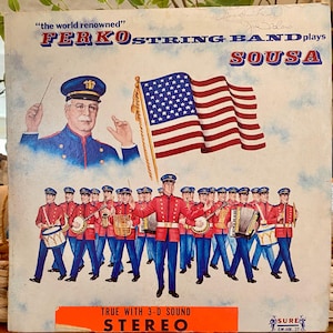 May include: Vintage album cover featuring the Ferko String Band playing Sousa. The cover art depicts a band in red and blue uniforms, an American flag, and the text "the world renowned". The album is labeled "Stereo".
