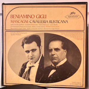 Puede incluir: Una portada de álbum de disco de vinilo vintage con una foto en blanco y negro del cantante de ópera Beniamino Gigli. El álbum se titula "Cavalleria Rusticana" de Mascagni. La portada del álbum también incluye el texto "Seraphim" y "Dos discos, con libreto".