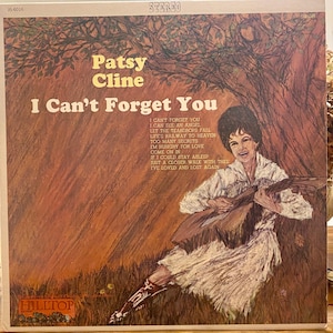 May include: Vintage vinyl record album cover for Patsy Cline's "I Can't Forget You." The cover art features a painted illustration of Cline playing a guitar, with text including the album title and song list. The album is labeled "STEREO."
