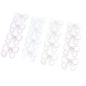 Puede incluir: Un conjunto de 15 pegatinas de lazo blanco iridiscente. Los lazos están delineados en color plateado.