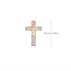 Może przedstawiać: Kwiatowy krzyż wykonany z różowych, żółtych, niebieskich i białych kwiatów. Krzyż ma 15,4 cm wysokości.