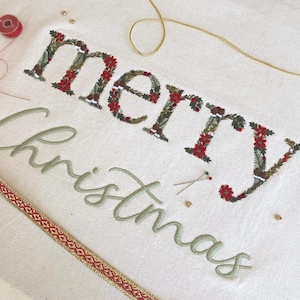 Motif floral de broderie machine joyeux Noël 25 cm/10" lettres héritage poinsettia feuilles de houx pommes de pin neige Noël police d'écriture délicate
