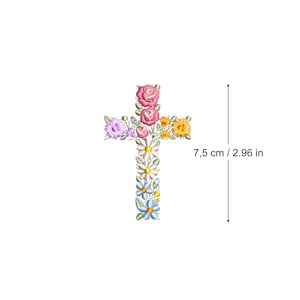 Może przedstawiać: Biały krzyż z kwiatowym wzorem. Krzyż składa się z różowych, żółtych, niebieskich i białych kwiatów. Krzyż ma 7,5 cm / 2,96 cala wysokości.