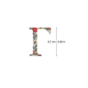 Puede incluir: Letra bordada "Γ" (Gamma) con temática navideña. La letra está adornada con flores de pascua rojas, hojas verdes de acebo, piñas y bayas rojas. La altura de la letra es de 9,7 cm.