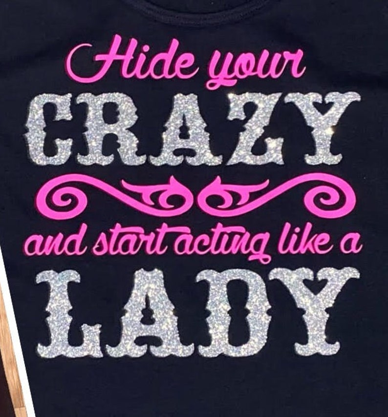 May include: Black t-shirt with the text "Hide your crazy and start acting like a lady" in pink and silver glitter.