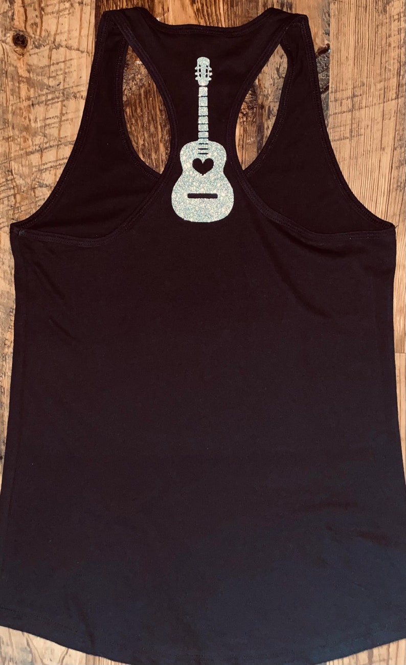 May include: Black tank top with a silver glitter guitar design on the back.