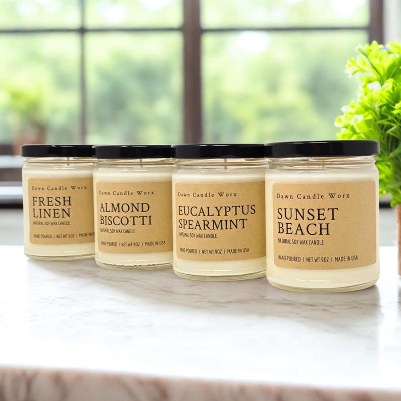 May include: Four clear glass jars filled with white soy wax, each topped with a black lid. The labels read Dawn Candle Worx and feature the scents Fresh Linen, Almond Biscotti, Eucalyptus Spearmint, and Sunset Beach, with a net weight of 9 oz.
