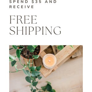 May include: A lit candle in a white glass container sits on a wooden crate next to a potted plant with green leaves. The image also contains the text "SPEND $35 AND RECEIVE FREE SHIPPING."