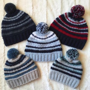 以下が含まれることがあります： 青、グレー、白、赤、黒など、さまざまな色のポンポンが付いた、ストライプのクロシェハットが5つあります