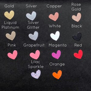 May include: A chart of heart-shaped paint samples in various colours, including gold, silver, copper, rose gold, liquid platinum, silver glitter, white, black, pink, grapefruit, magenta, red, lilac sparkle, and orange.