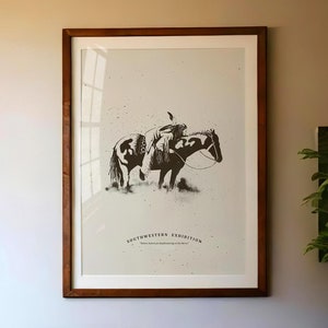 May include: A framed black and white print of a Native American riding a horse. The print is titled "Southwestern Exhibition" and includes the text "Native American horseback riding in the desert".