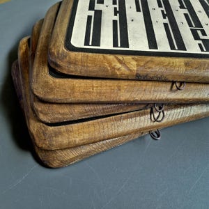 May include: Stack of four wooden framed signs with black and white text and a black border. The signs are stacked on top of each other and have a rustic, distressed look.