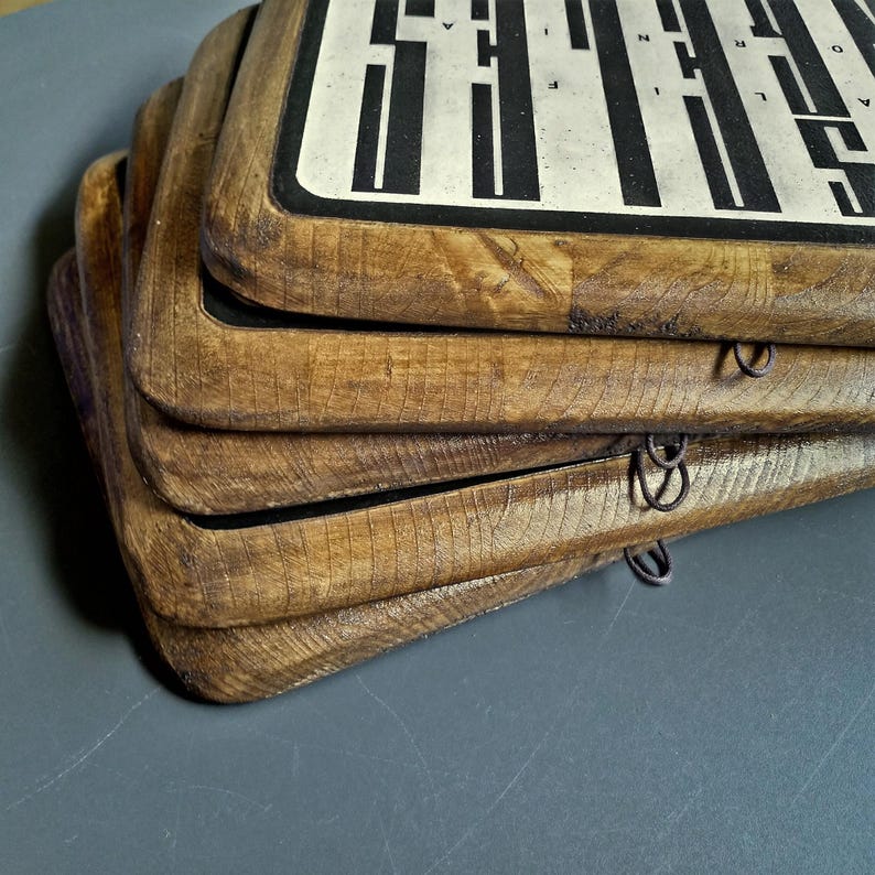 May include: Stack of four wooden framed signs with black and white text and a black border. The signs are stacked on top of each other and have a rustic, distressed look.