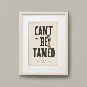 Pu&ograve; includere: Una stampa incorniciata con il testo "CAN'T BE TAMED" in grassetto nero. La stampa presenta anche una piccola illustrazione di una donna in gonna e cappello in piedi con le braccia incrociate. Il testo "SOUTHWESTERN EXHIBITION" &egrave; stampato sotto il testo principale.