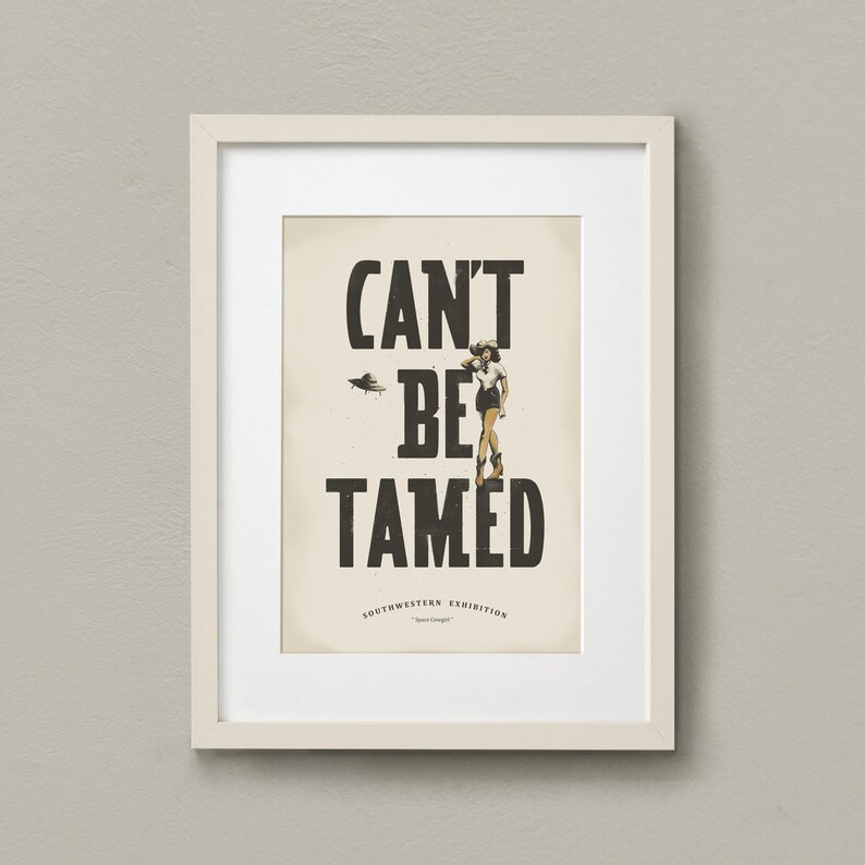 Pu&ograve; includere: Una stampa incorniciata con il testo "CAN'T BE TAMED" in grassetto nero. La stampa presenta anche una piccola illustrazione di una donna in gonna e cappello in piedi con le braccia incrociate. Il testo "SOUTHWESTERN EXHIBITION" &egrave; stampato sotto il testo principale.