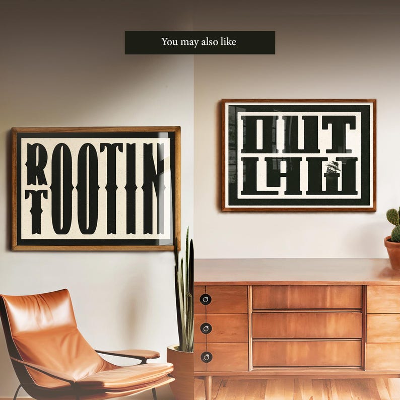 May include: Two framed prints with black text on a white background. The print on the left says "ROOTIN'" and the print on the right says "OUT LAW". The prints are hanging on a wall above a wooden dresser.