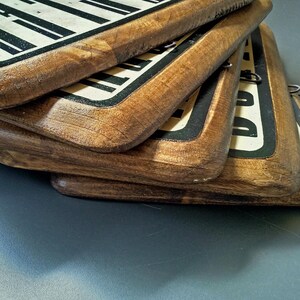 May include: Four wooden signs with black and white text stacked on top of each other. The signs have a distressed, rustic look.