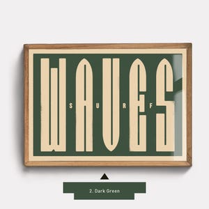 May include: A framed print with the word "WAVES" in a stylized font. The letters are formed by surfboard shapes. The background is dark green and the letters are a light cream color.
