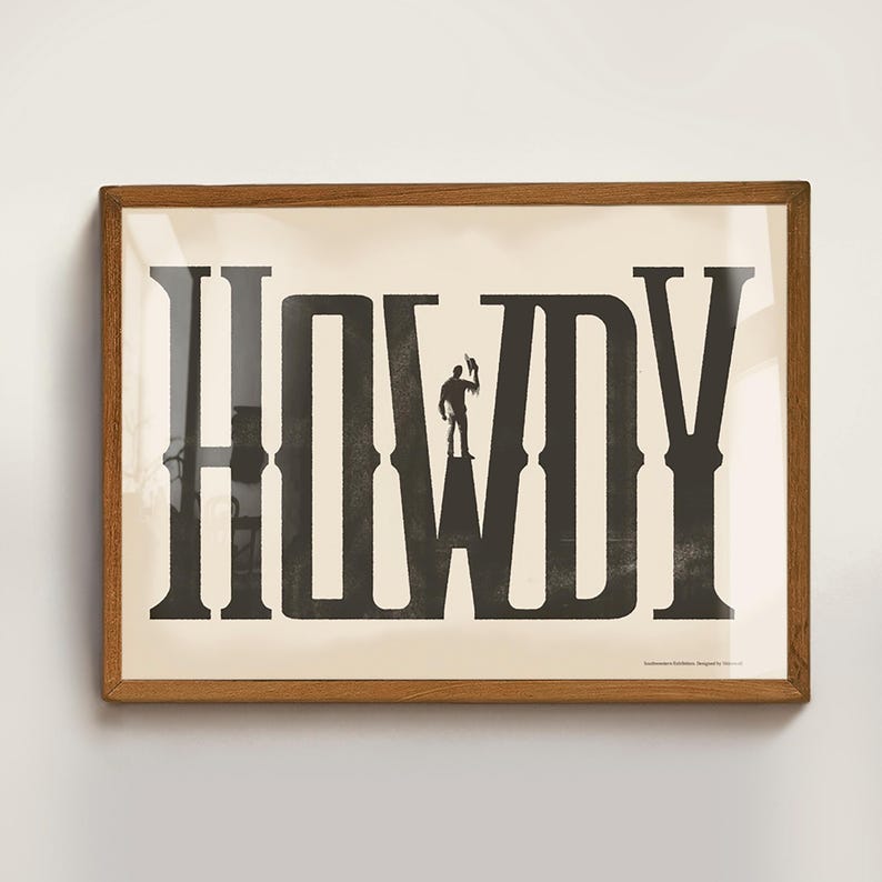 K&ouml;nnte beinhalten: Ein gerahmter Druck mit einem schwarz-wei&szlig;en Design des Wortes "HOWDY" mit einer Silhouette eines Cowboys, der auf dem "W" steht.