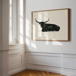 May include: A framed black and white illustration of a longhorn steer lying down. The steer is silhouetted against a light beige background. The text "Longhorn" is printed in black below the steer.