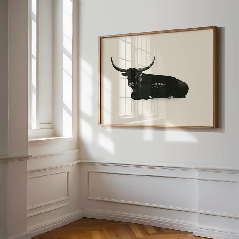 May include: A framed black and white illustration of a longhorn steer lying down. The steer is silhouetted against a light beige background. The text "Longhorn" is printed in black below the steer.