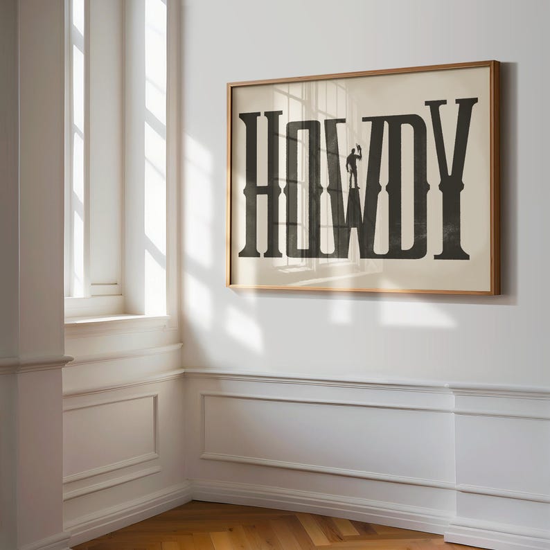K&ouml;nnte beinhalten: Ein gerahmter Druck mit dem Wort "HOWDY" in gro&szlig;en, fetten, schwarzen Buchstaben. Eine Silhouette eines Cowboys steht auf dem Buchstaben "W".