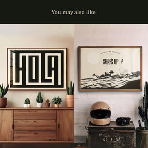 Puede incluir: Dos impresiones enmarcadas en una pared sobre una c&oacute;moda de madera. La impresi&oacute;n de la izquierda dice "HOLA" en blanco y negro. La impresi&oacute;n de la derecha es una ilustraci&oacute;n en blanco y negro de un surfista con el texto "SOUTHWESTERN EDITION SURF'S UP" sobre el surfista.