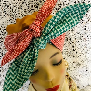 Może przedstawiać: Turban w czerwono-zielone wzory z akcentem ze złotej tkaniny. Turban jest zawiązany w supeł na górze głowy.