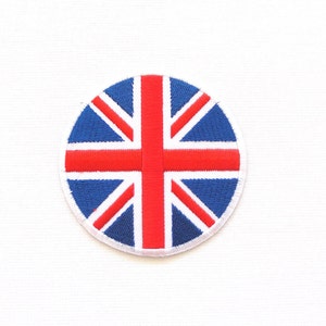 Pode incluir: Um remendo redondo bordado com o design da bandeira da Union Jack. A bandeira é vermelha, branca e azul.