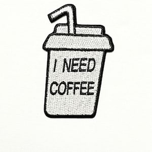 May include: A white embroidered patch of a coffee cup with a straw and the text "I NEED COFFEE".