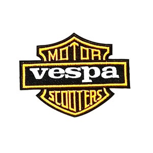 May include: Black and yellow embroidered patch with the text "Vespa Motor Scooters" in a shield shape.