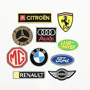 Può includere: Una collezione di toppe ricamate con loghi di vari marchi automobilistici, tra cui Citroën, Ferrari, Mercedes-Benz, Audi, Land Rover, MG, BMW, Ford, Renault e Mini. Le toppe sono di varie forme e colori.