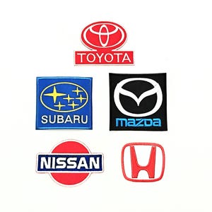 May include: Embroidered patches displaying car brand logos. Logos include Toyota, Subaru, Mazda, Nissan, and Honda. Each patch has a unique colour scheme and brand name.