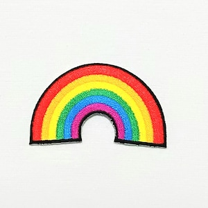 May include: An embroidered patch shaped like a rainbow arc, featuring a rainbow of colours. The patch is made of felt and has a black outline.