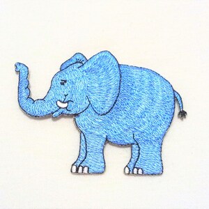 Könnte beinhalten: Blauer gestickter Elefanten-Applikations-Patch. Der Elefant steht mit erhobenem Rüssel und hat einen weißen Stoßzahn.